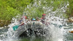 A paddle raft charges through Ned’s Gulch rapid while whitewater rafting on the Merced River in California with ARTA river trips