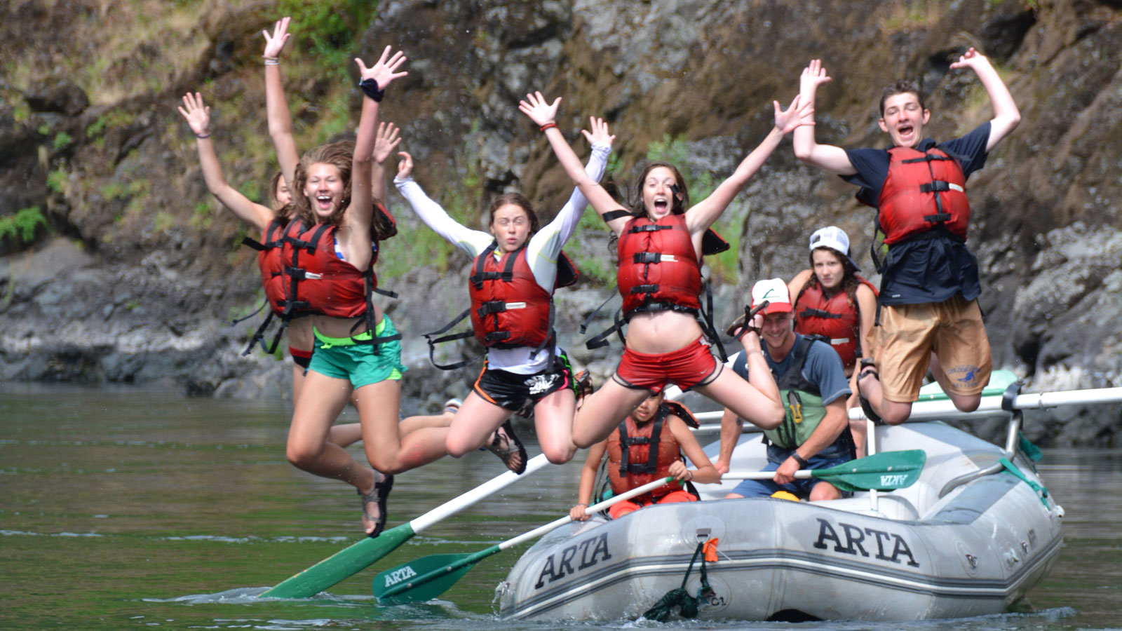 jumping-in-the-river-rogue-river-junior-whitewater-school-arta-river-trips Kids jumping out of a raft into the Rogue River in Oregon with ARTA River Trips
