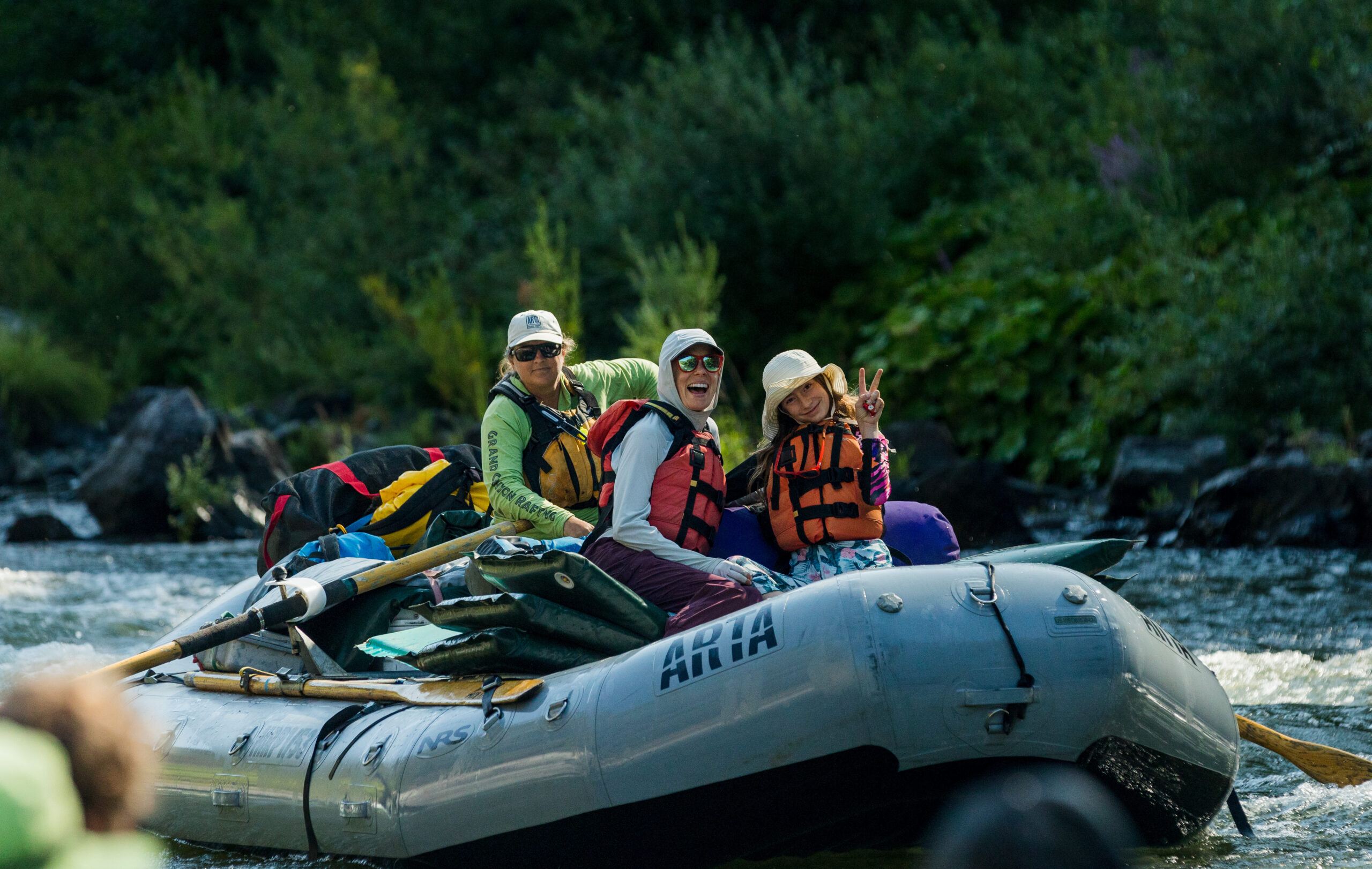 A river paddles her raft with customers in the boat