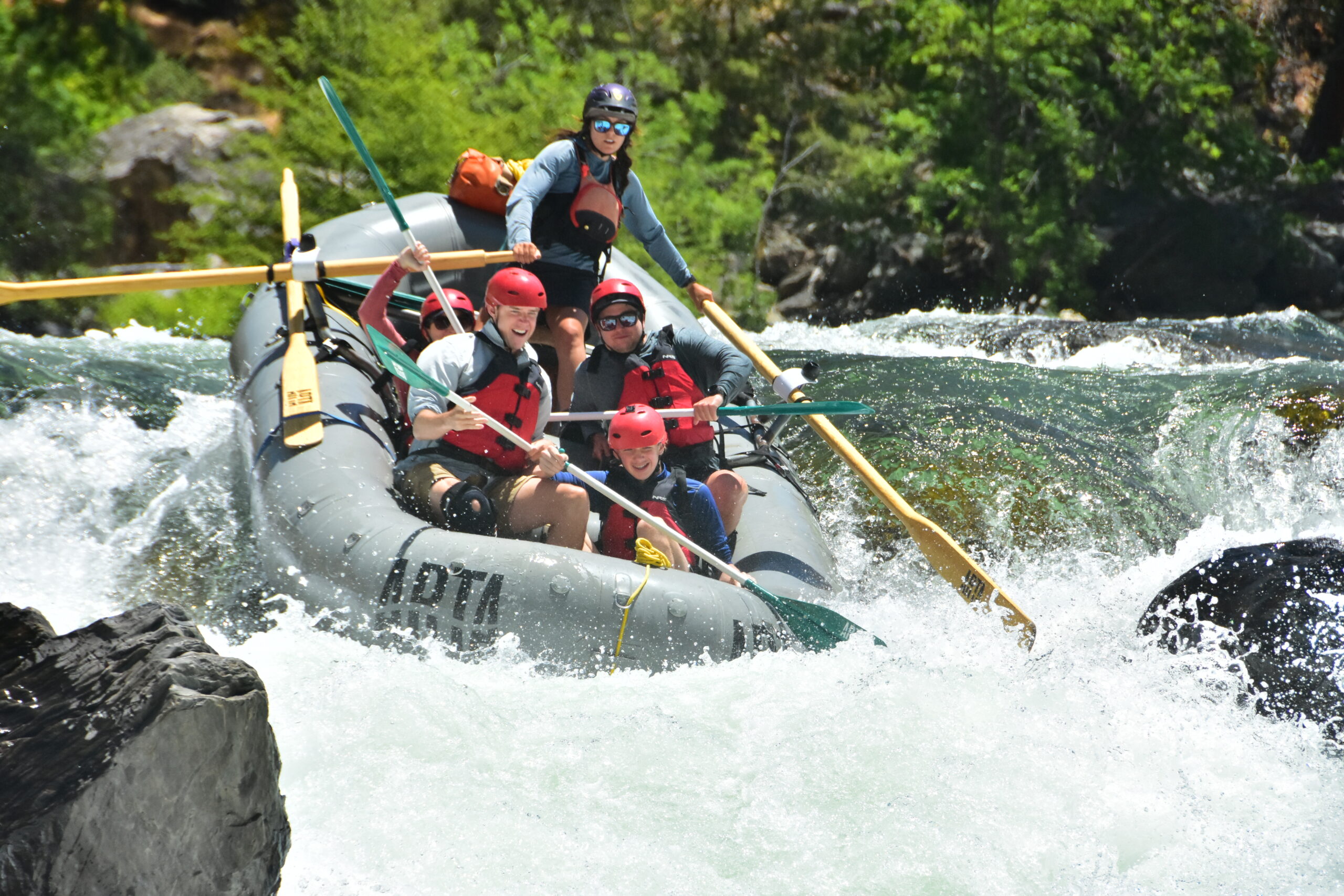 A boat with 5 people on a raft trip