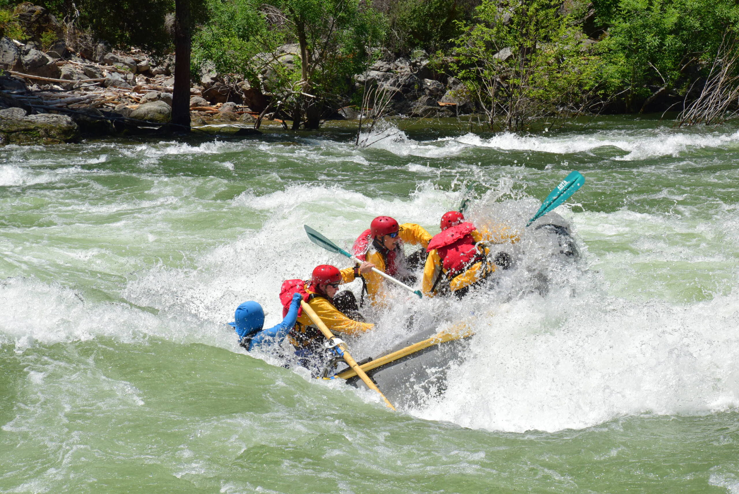 a person guide a grey boat through big rapids