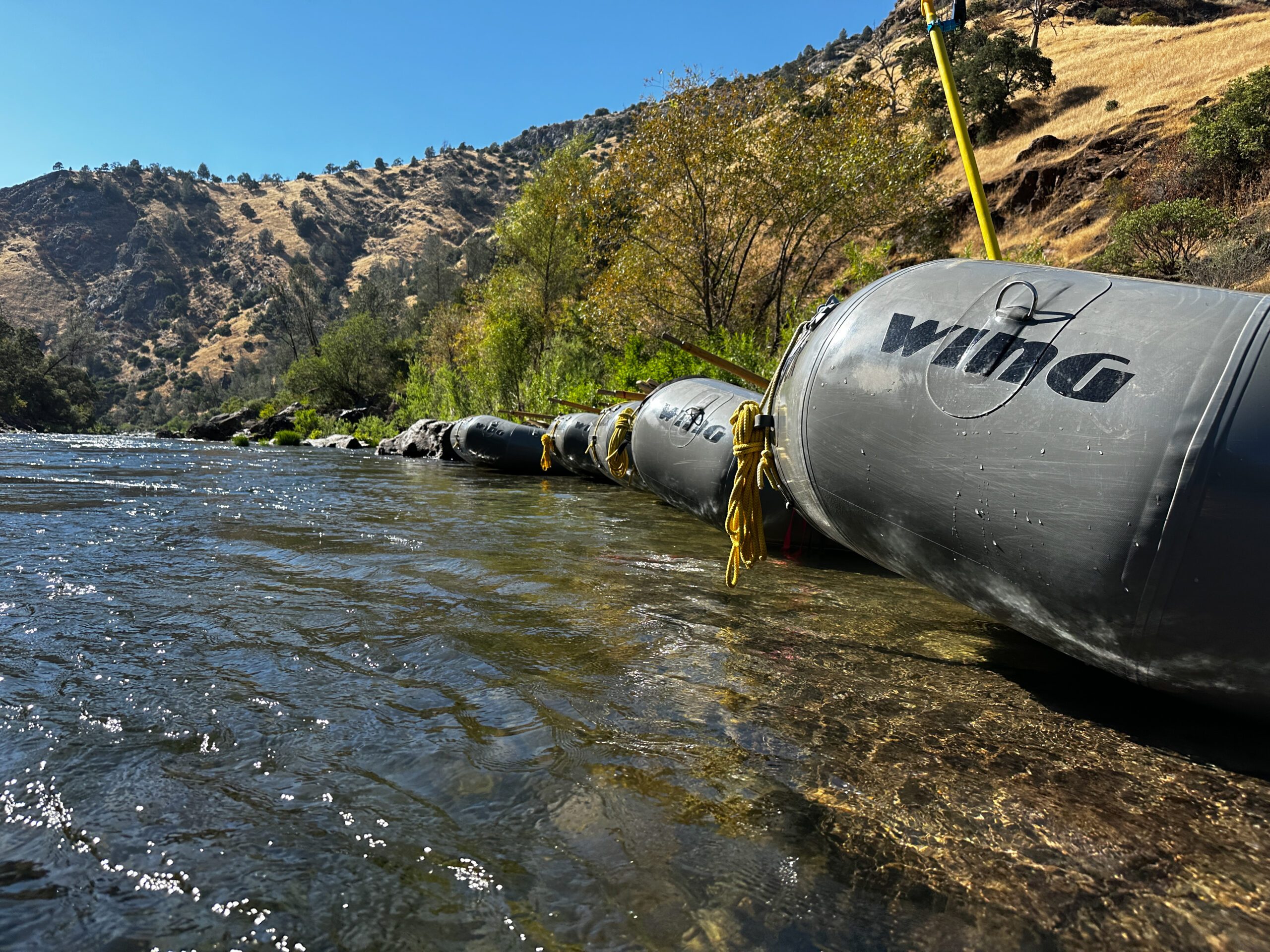 Boats sit on the shore of the tuolumne river