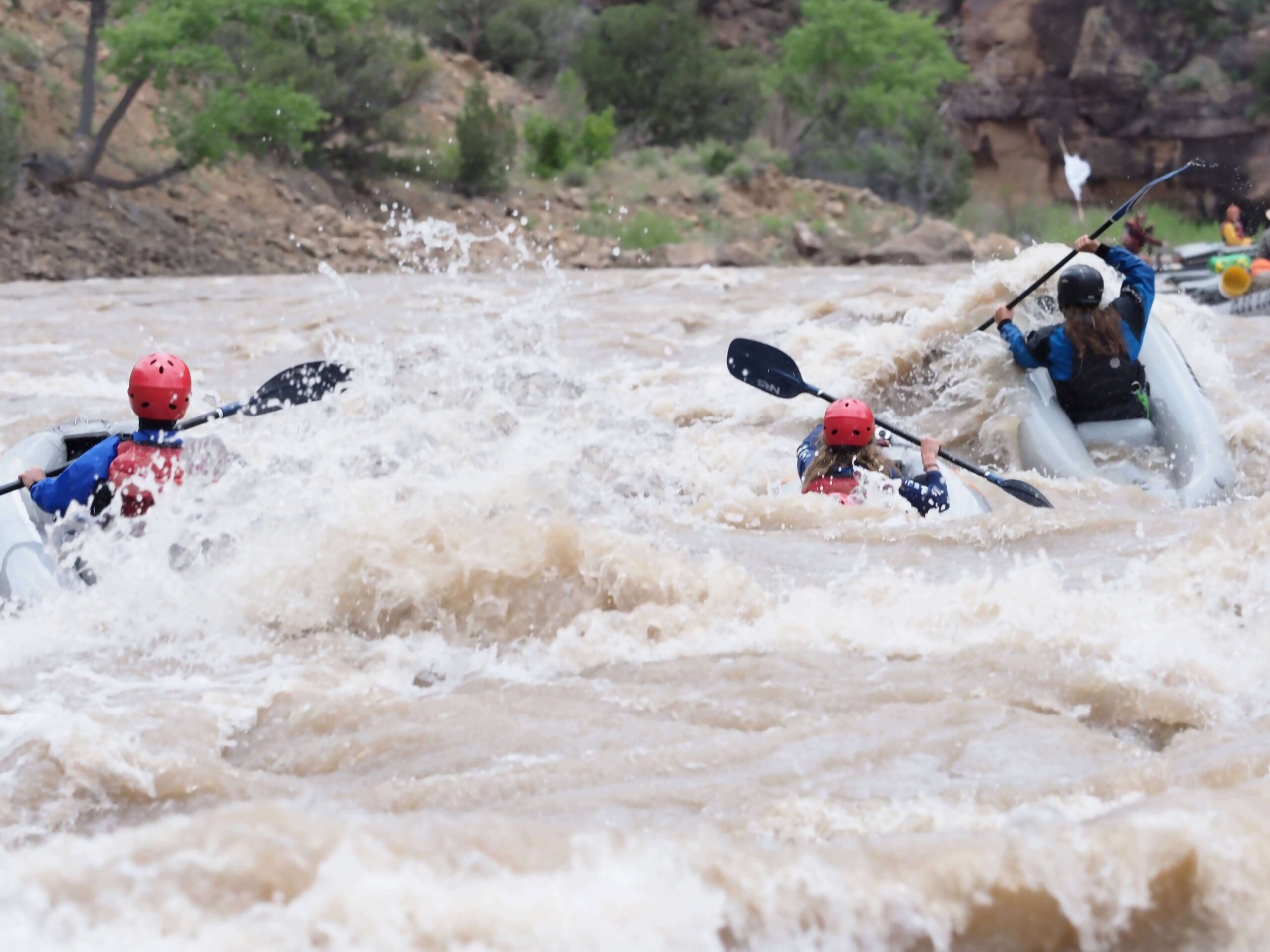 kayaks paddle through white water on a river