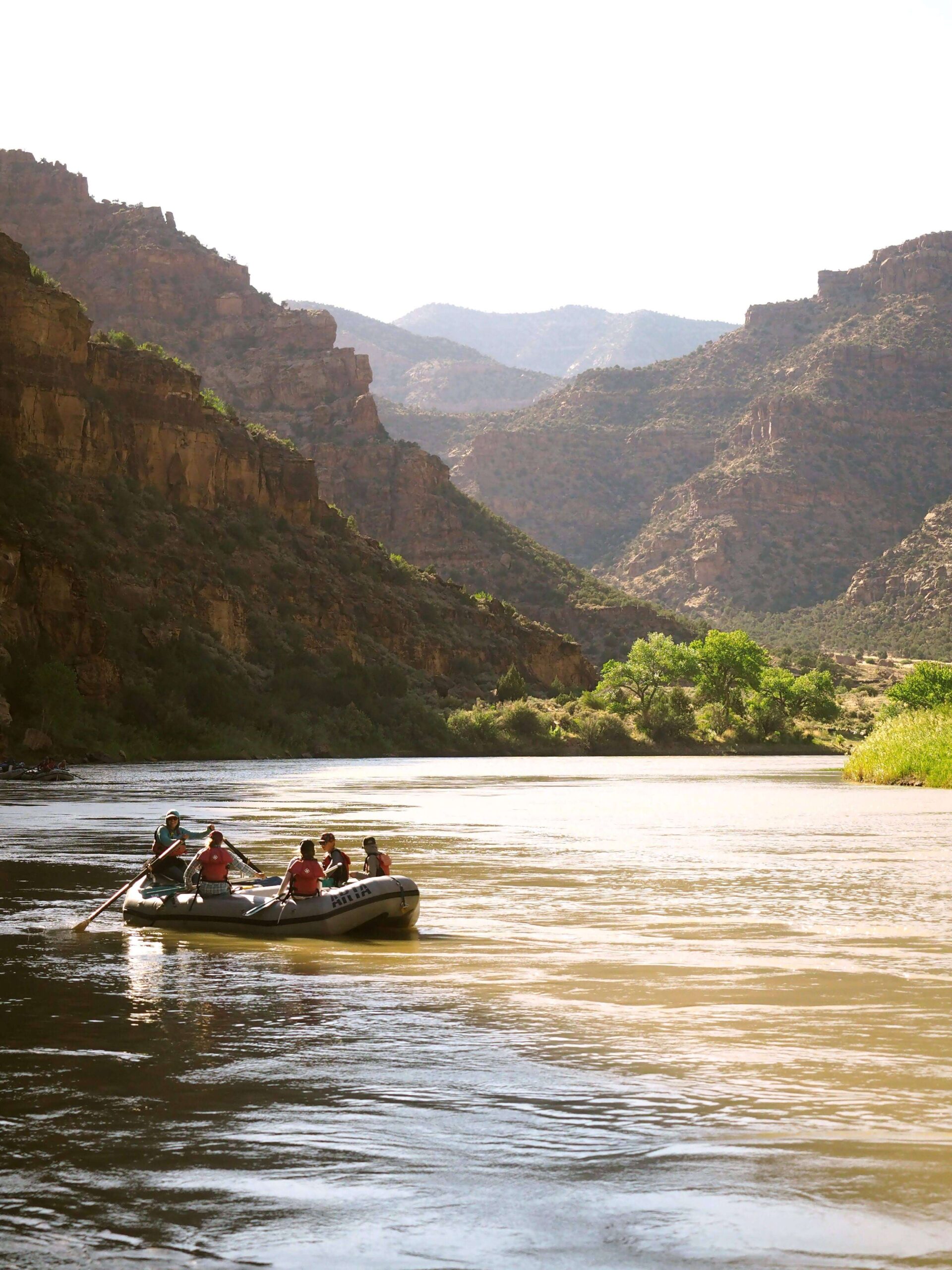 a raft floats down a scenic stretch of river
