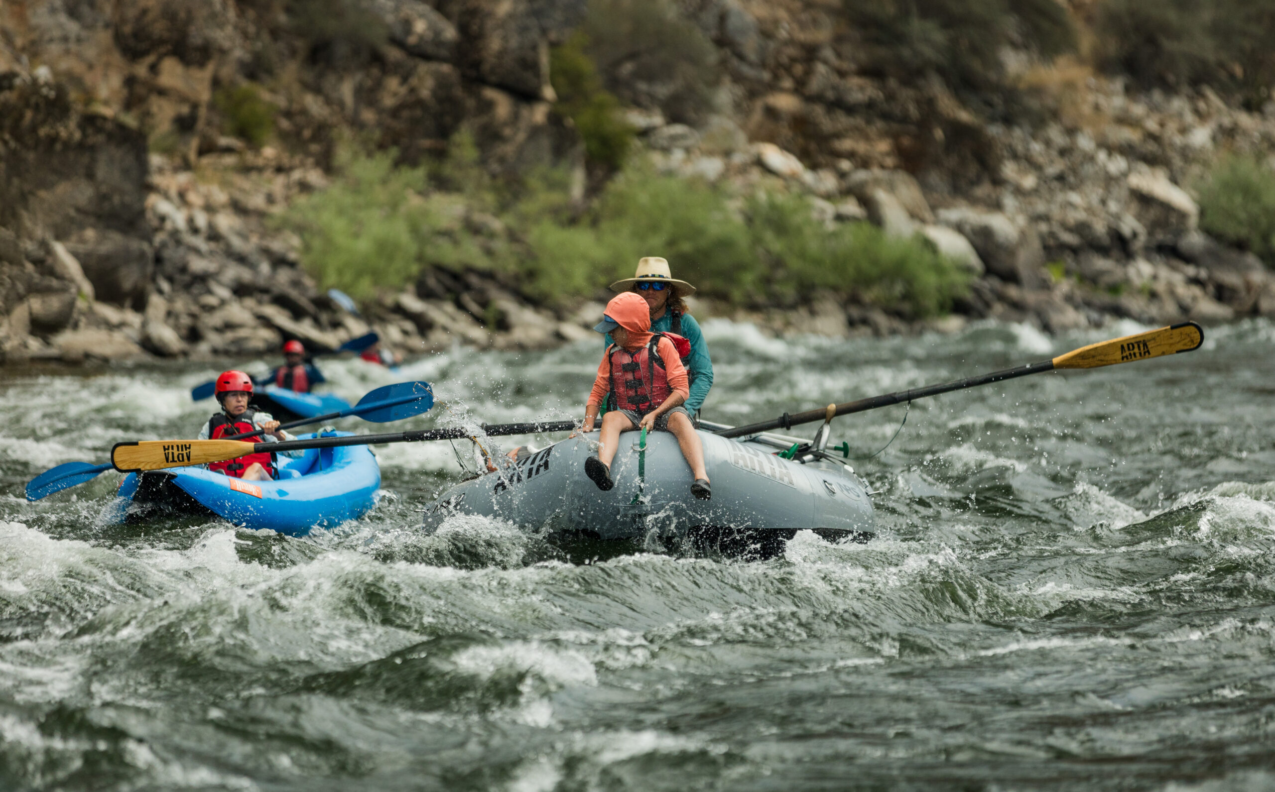 A person sits on the front of a raft