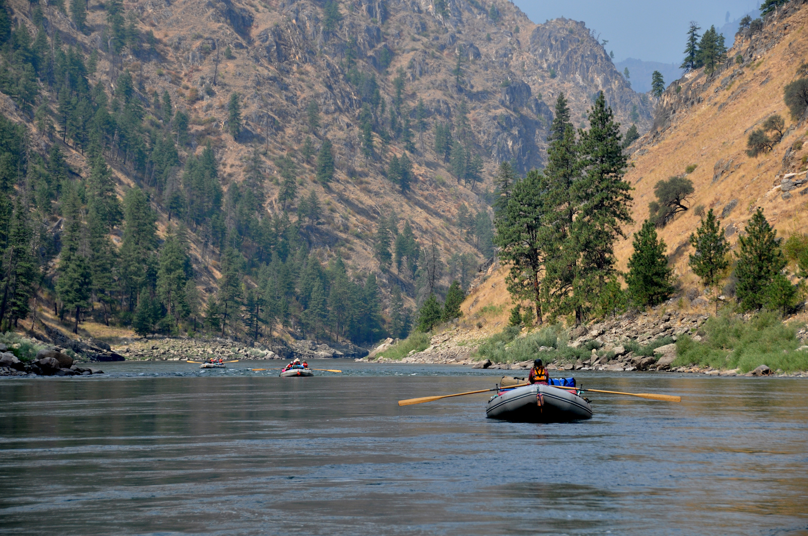 A boat floats down a scenic stretch of water