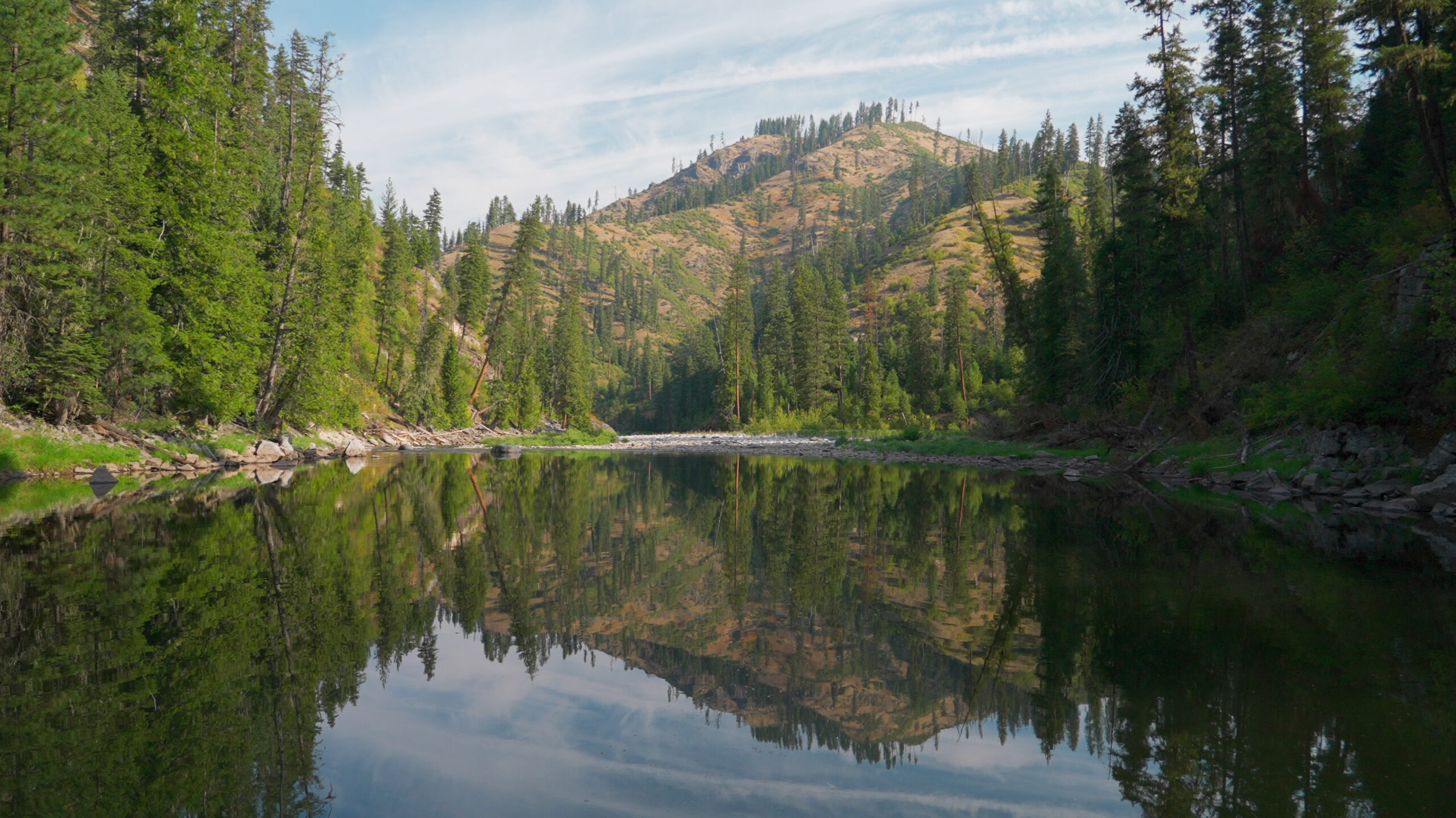 Reflection of a mountain on a calm river