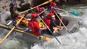 people on a grey raft on the river